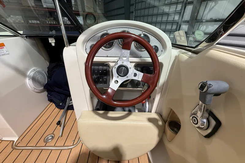 Slide: The Image of 2005 Chris-Craft Launch 22 boat dashboard with wooden steering wheel and control panel. - 13