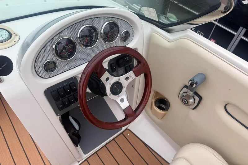 Slide: The Image of 2005 Chris-Craft Launch 22 dashboard with wooden steering wheel and control panel. - 3