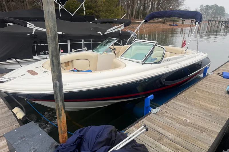 Slide: The Image of 2005 Chris-Craft Launch 22 boat docked at a marina, featuring elegant design and spacious seating. - 6