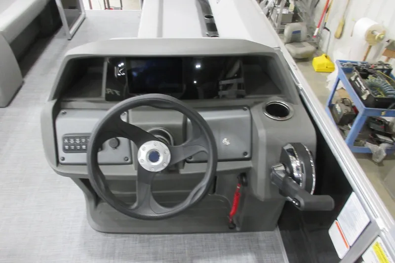 Slide: The Image of 2026 Sun Tracker Party Barge 18 DLX steering console with controls and cup holder. - 6