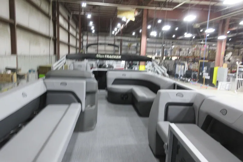 Slide: The Image of 2026 Sun Tracker Party Barge 18 DLX interior in a warehouse setting. - 7