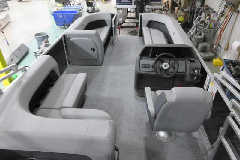 Slide: The Image of 2026 Sun Tracker Party Barge 18 DLX interior with gray seating and steering console. - 9