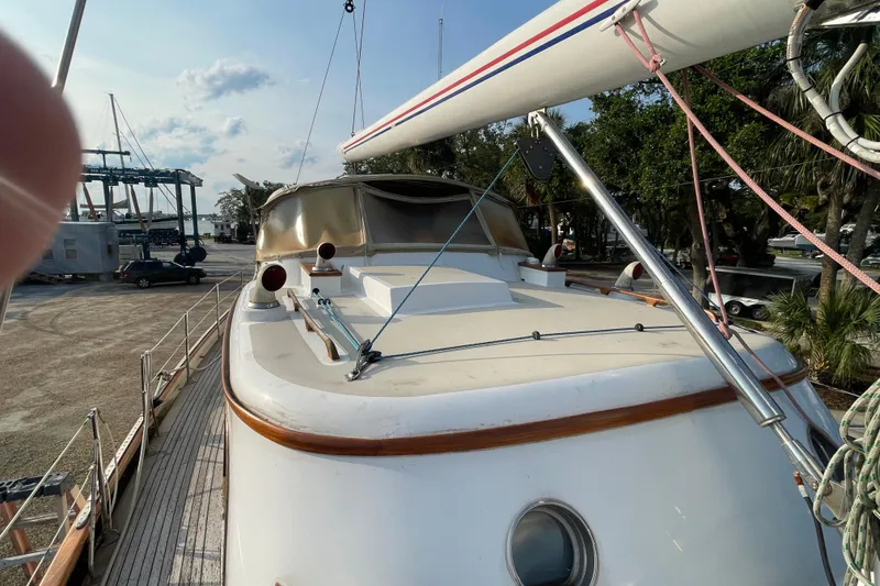 Slide: The Image of 1972 Rhodes 53 Motorsailor yacht on dry dock, showcasing deck and rigging. - 16