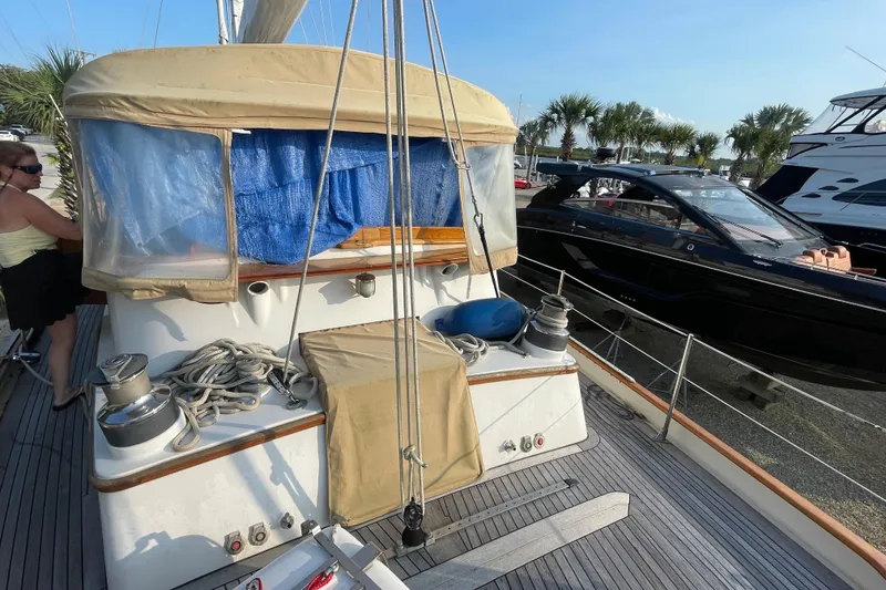 Slide: The Image of 1972 Rhodes 53 Motorsailor docked, featuring deck details and nearby yachts. - 19