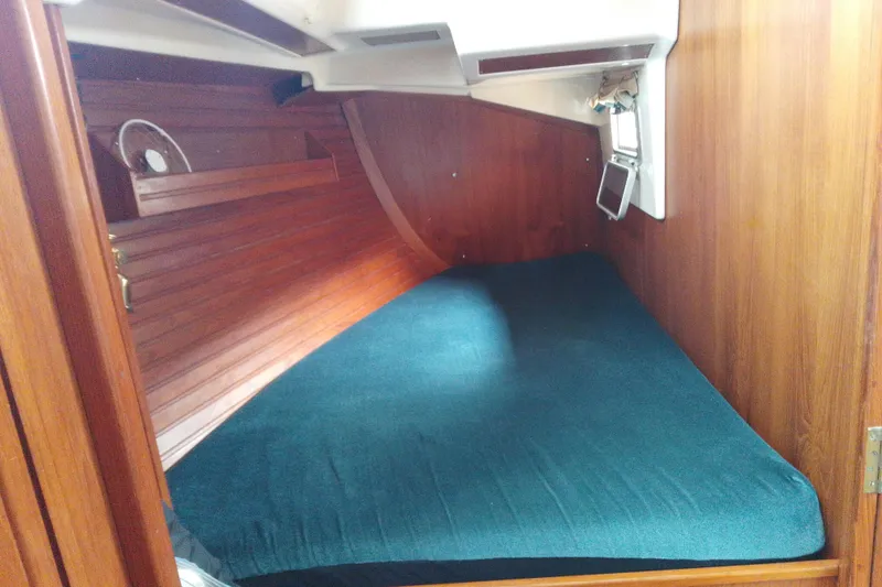 Slide: The Image of Cozy cabin interior of 1972 Rhodes 53 Motorsailor with wooden paneling and blue bedding. - 24