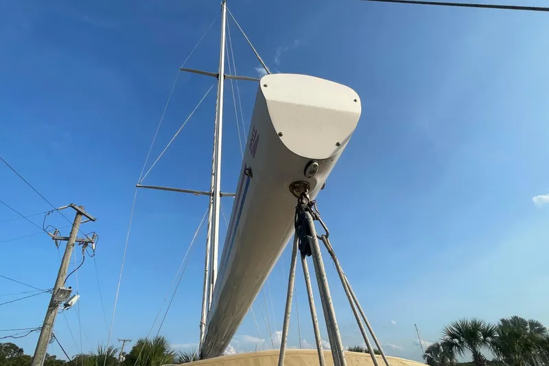 Slide: The Image of 1972 Rhodes 53 Motorsailor mast against clear blue sky, with rigging and power lines visible. - 25