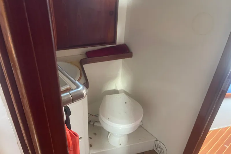 Slide: The Image of 1972 Rhodes 53 Motorsailor bathroom with wooden accents and compact toilet. - 38