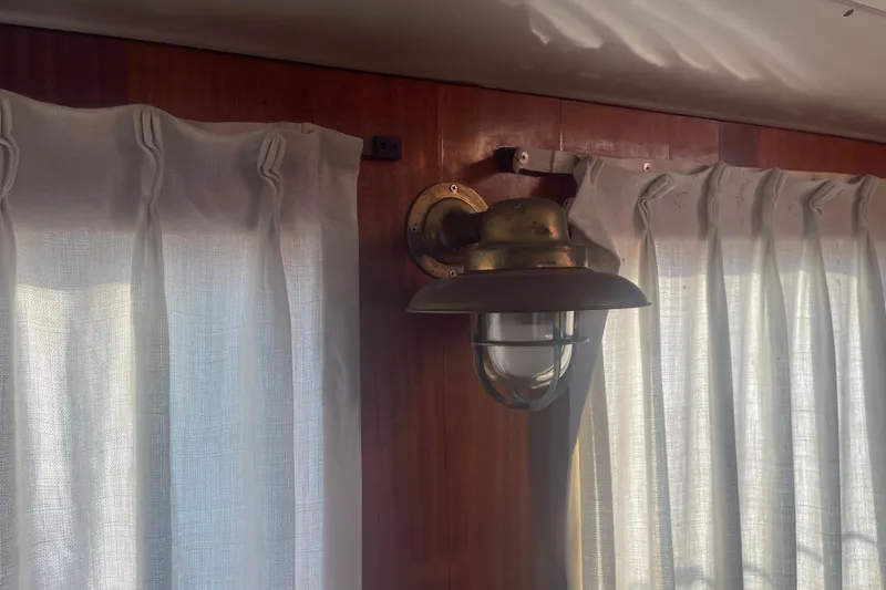 Slide: The Image of Vintage brass wall lamp on 1972 Rhodes 53 Motorsailor with white curtains. - 50