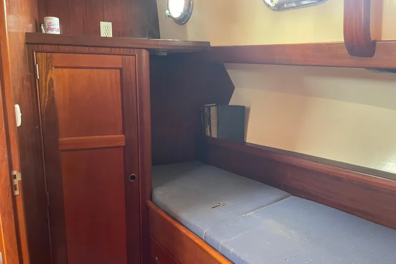 Slide: The Image of Cozy cabin interior of 1972 Rhodes 53 Motorsailor with wooden furnishings and blue cushion. - 57