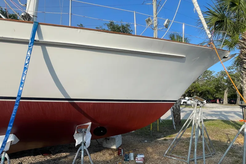 Slide: The Image of 1972 Rhodes 53 Motorsailor on stands, undergoing maintenance in a sunny outdoor setting. - 6