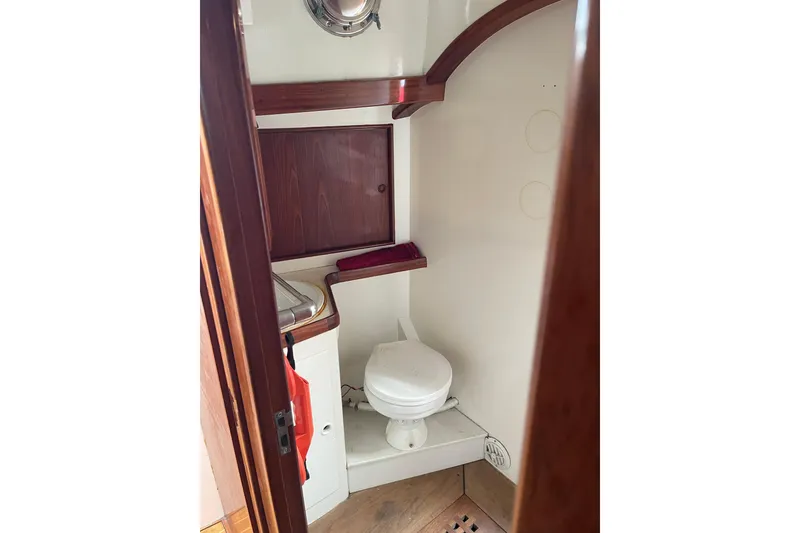 Slide: The Image of 1972 Rhodes 53 Motorsailor bathroom with wooden accents and compact design. - 64