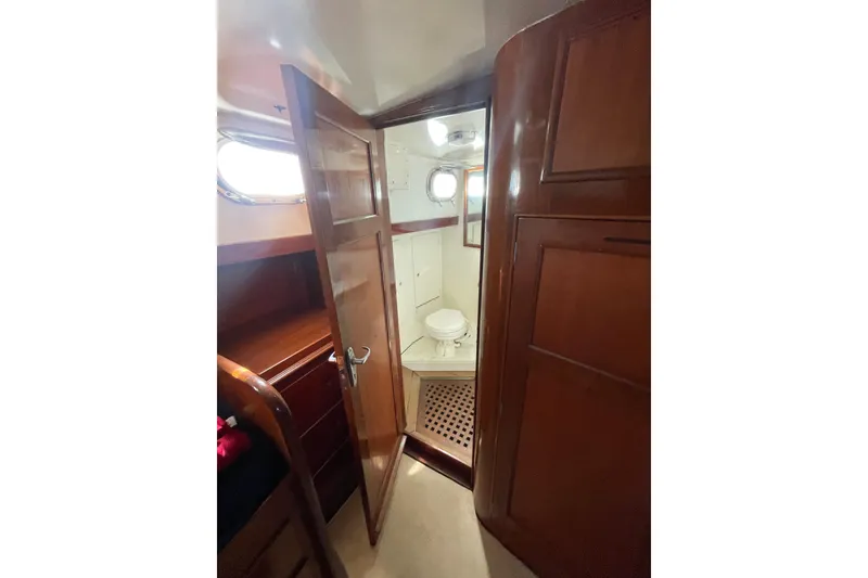Slide: The Image of Interior of 1972 Rhodes 53 Motorsailor showing wooden cabinetry and compact bathroom. - 68