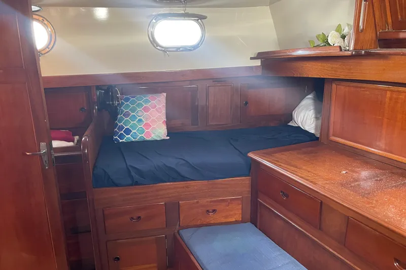Slide: The Image of Cozy cabin interior of 1972 Rhodes 53 Motorsailor with wooden furnishings and colorful pillow. - 74