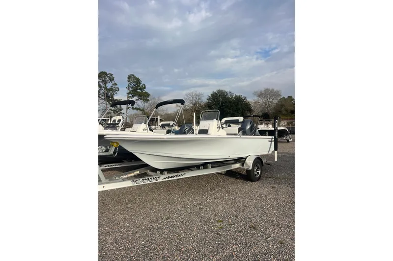 Slide: The Image of 2026 Tidewater 1910 Bay Max boat on trailer, parked outdoors under cloudy sky. - 2