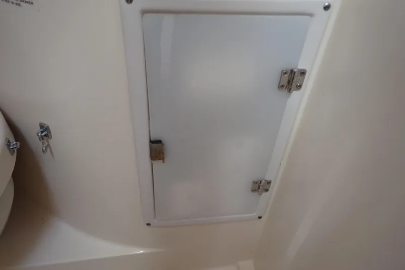 Slide: The Image of 2006 Wellcraft 330 Coastal interior compartment door with latch and hinges. - 105