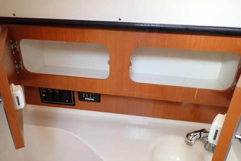 Slide: The Image of 2006 Wellcraft 330 Coastal interior cabinet with open doors and sink. - 110