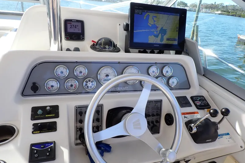 Slide: The Image of 2006 Wellcraft 330 Coastal helm with navigation instruments and steering wheel, overlooking water. - 113