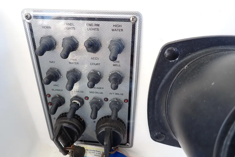 Slide: The Image of Control panel of a 2006 Wellcraft 330 Coastal boat with various switches and keys. - 118