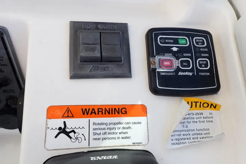 Slide: The Image of Control panel of a 2006 Wellcraft 330 Coastal boat with warning labels and emergency buttons. - 119