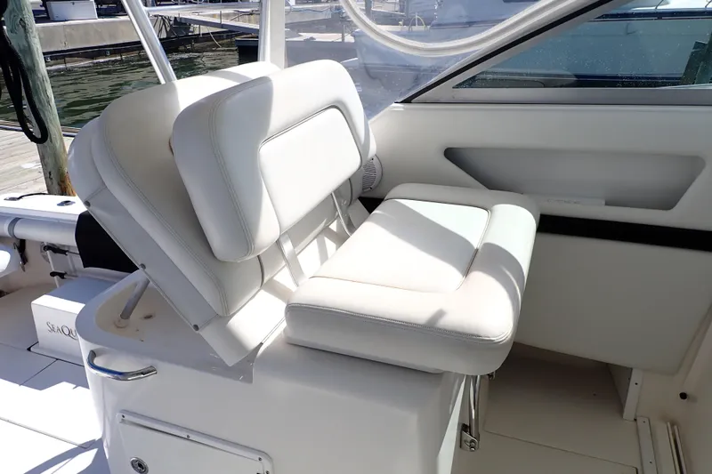 Slide: The Image of 2006 Wellcraft 330 Coastal boat interior with white seating and dock view. - 12