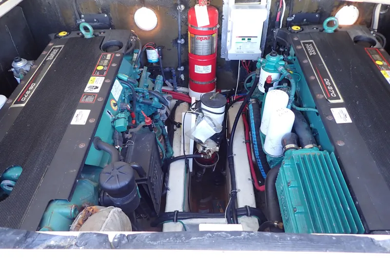 Slide: The Image of Engine compartment of a 2006 Wellcraft 330 Coastal boat, featuring dual engines and fire extinguisher. - 129