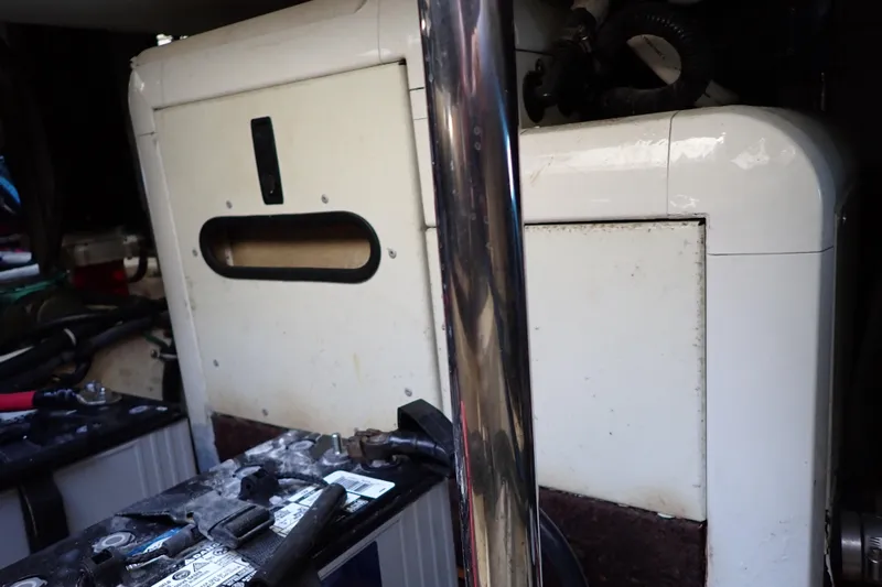 Slide: The Image of 2006 Wellcraft 330 Coastal engine compartment with visible battery and equipment. - 133