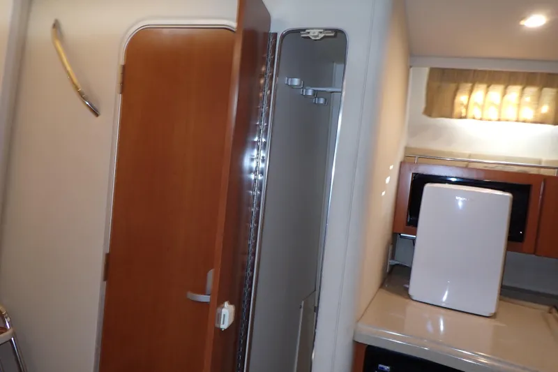 Slide: The Image of Interior of 2006 Wellcraft 330 Coastal boat, featuring kitchenette and wooden door. - 139