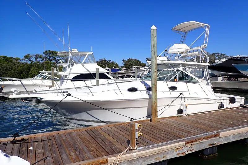 Slide: The Image of 2006 Wellcraft 330 Coastal boat docked at marina under clear blue sky. - 140