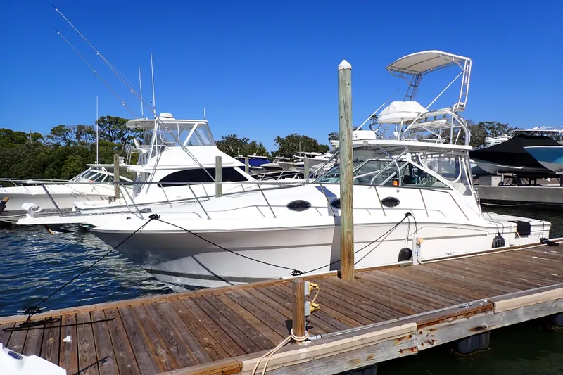 Slide: The Image of 2006 Wellcraft 330 Coastal boat docked at marina under clear blue sky. - 2