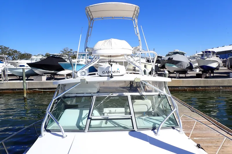 Slide: The Image of 2006 Wellcraft 330 Coastal boat docked, featuring Garmin equipment, under clear blue sky. - 22