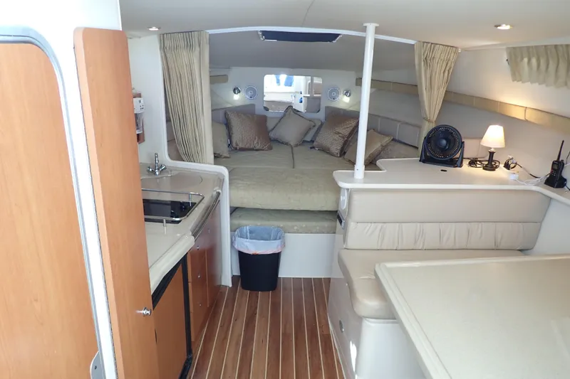 Slide: The Image of 2006 Wellcraft 330 Coastal cabin interior with bed, kitchenette, and seating area. - 30