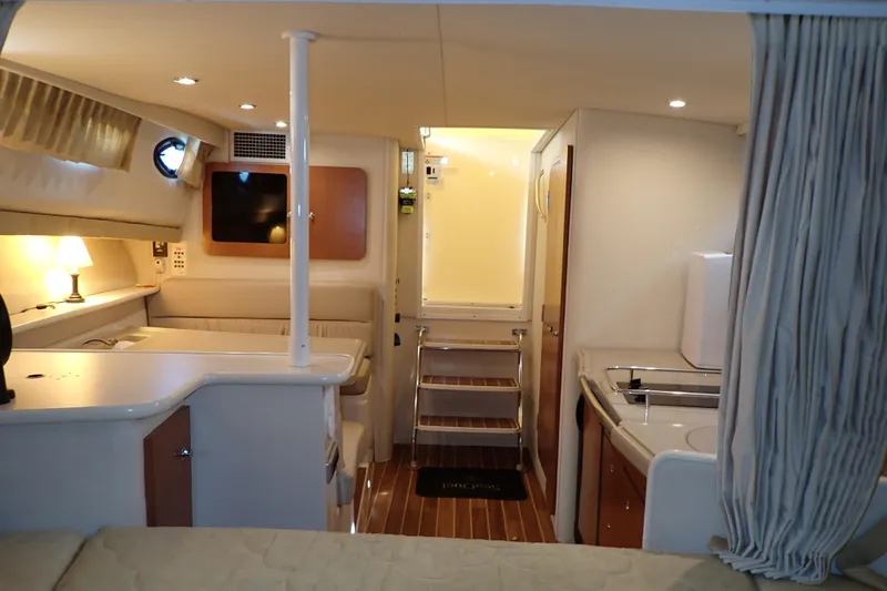 Slide: The Image of 2006 Wellcraft 330 Coastal interior with cozy seating, kitchenette, and ambient lighting. - 32