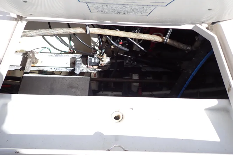 Slide: The Image of Engine compartment of a 2006 Wellcraft 330 Coastal boat, showing hoses and mechanical components. - 56