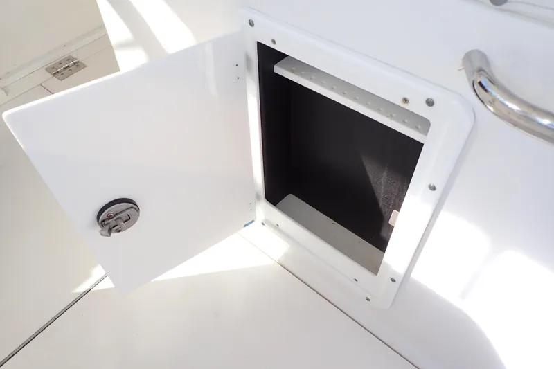 Slide: The Image of Open storage compartment on 2006 Wellcraft 330 Coastal boat, featuring a secure latch. - 65