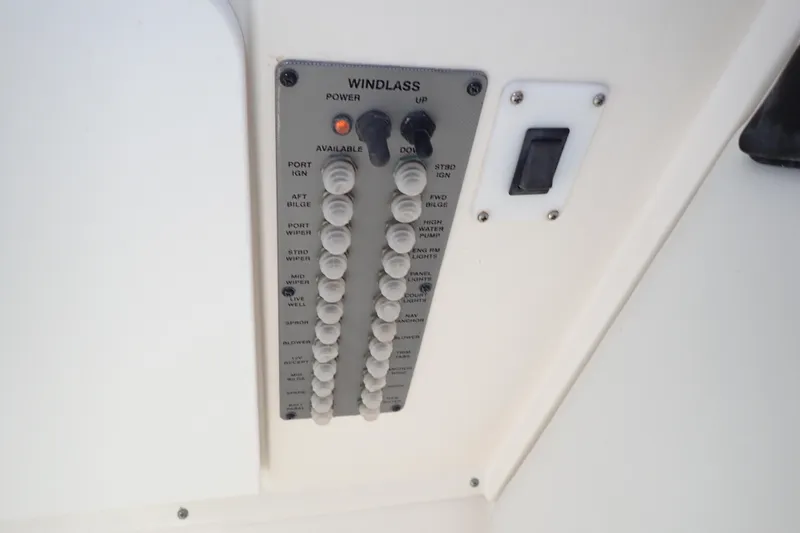Slide: The Image of Control panel of a 2006 Wellcraft 330 Coastal boat, featuring windlass and various switches. - 70