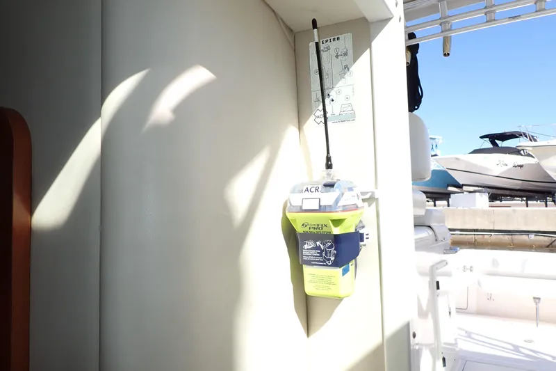 Slide: The Image of 2006 Wellcraft 330 Coastal boat with mounted emergency beacon, docked near other boats. - 75