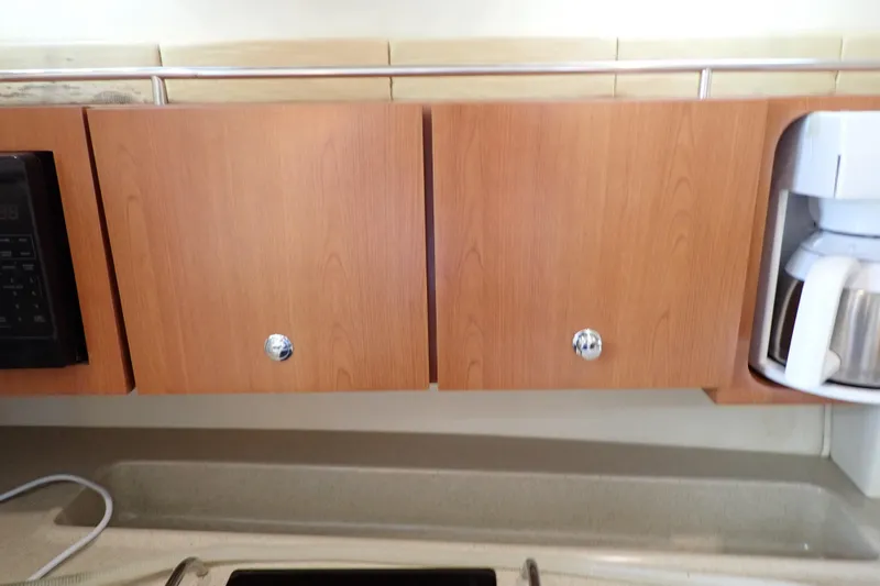 Slide: The Image of 2006 Wellcraft 330 Coastal kitchen cabinets with coffee maker and microwave. - 83