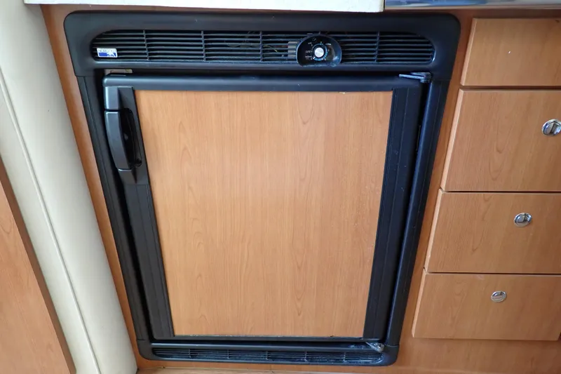 Slide: The Image of Wood-paneled refrigerator in 2006 Wellcraft 330 Coastal boat interior. - 89