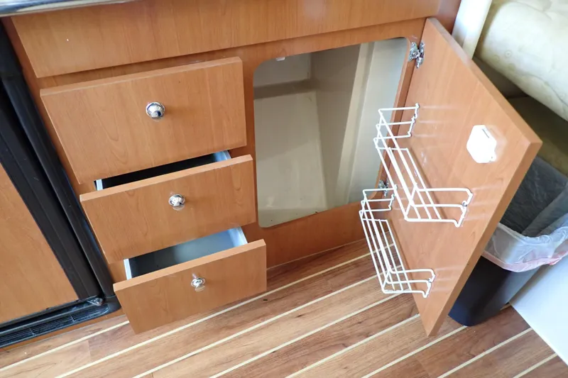 Slide: The Image of 2006 Wellcraft 330 Coastal interior with open wooden cabinets and drawers. - 92