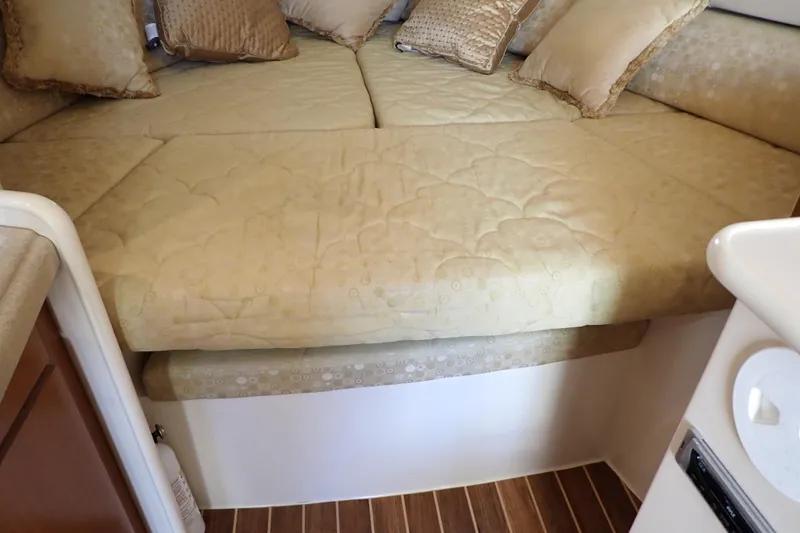 Slide: The Image of 2006 Wellcraft 330 Coastal cabin interior with beige bedding and pillows. - 93