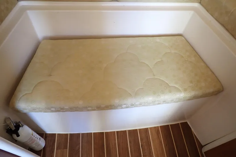 Slide: The Image of 2006 Wellcraft 330 Coastal cabin interior with cushioned bench and fire extinguisher. - 94