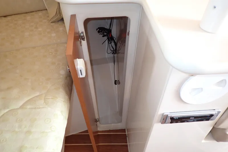 Slide: The Image of 2006 Wellcraft 330 Coastal interior storage compartment with open door, revealing wiring inside. - 97