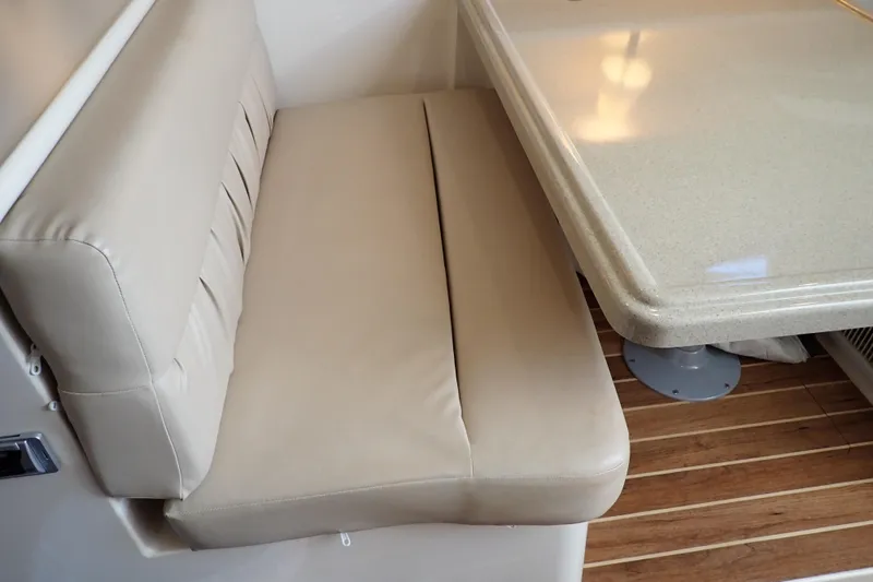 Slide: The Image of 2006 Wellcraft 330 Coastal interior with beige seating and table on wooden flooring. - 98