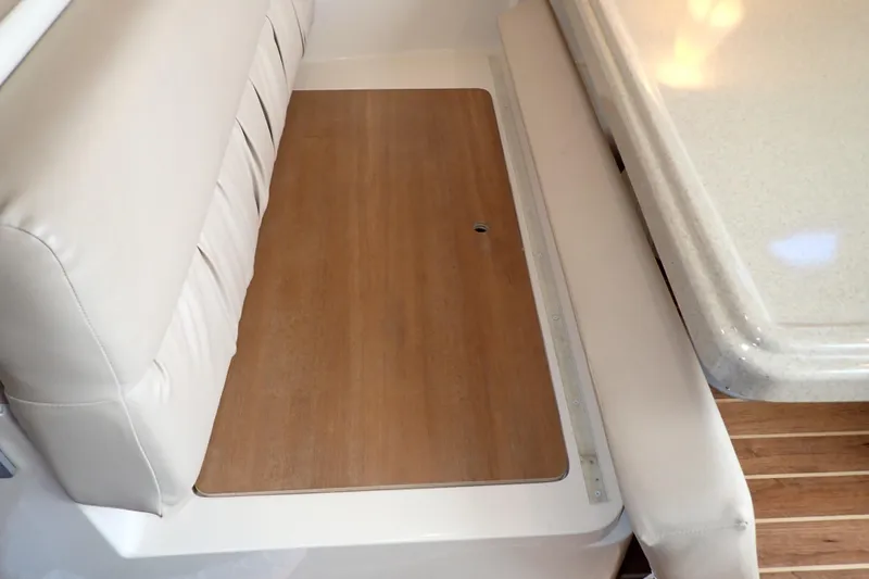 Slide: The Image of Interior seating and table on 2006 Wellcraft 330 Coastal boat, featuring wood and leather elements. - 99