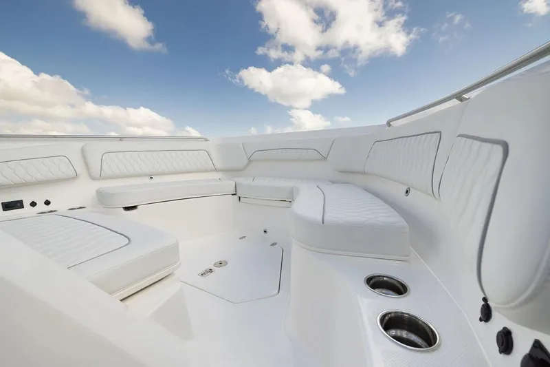 Slide: The Image of Manufacturer Provided Image: 2026 Pursuit S 388 Sport boat interior with white seating and cup holders under a blue sky. - 5