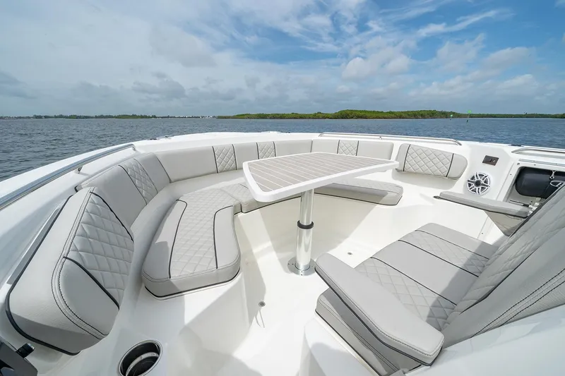 Slide: The Image of Manufacturer Provided Image: 2025 Pursuit S 358 Sport boat interior with luxurious seating and table on open water. - 6