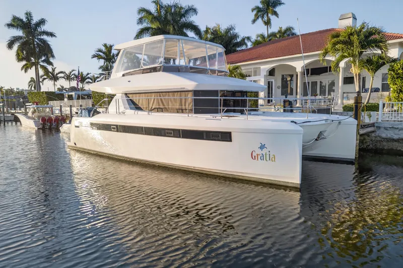 The Image of 2024 Leopard 46 Powercat yacht docked by a waterfront villa with palm trees. - 0