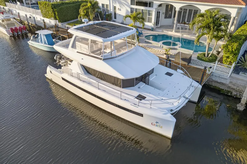 Slide: The Image of 2024 Leopard 46 Powercat yacht docked by a luxurious waterfront home. - 103