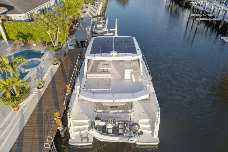Slide: The Image of 2024 Leopard 46 Powercat yacht docked by a luxurious waterfront home. - 104