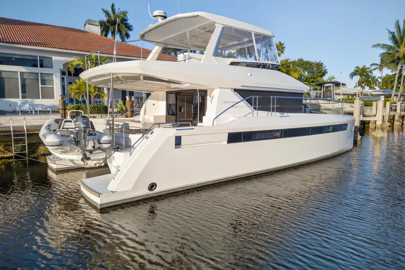 Slide: The Image of 2024 Leopard 46 Powercat yacht docked by waterfront home, sunny day. - 105